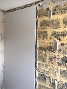 Plasterboard being fitted to wall
